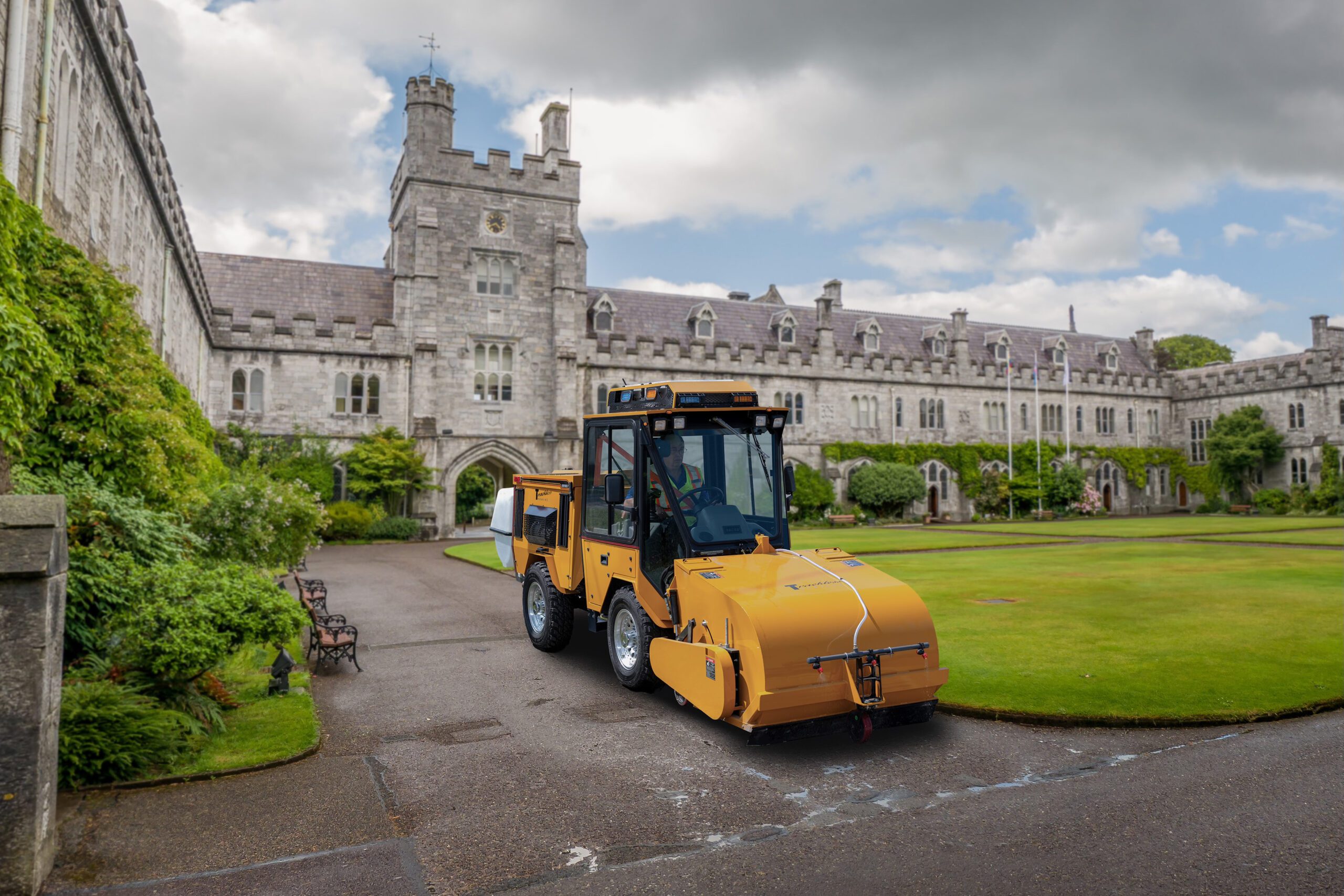 trackless vehicles pickup sweeper sweeping attachment sweeping dirt from sidewalk at university campus