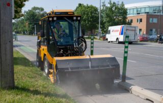 trackless vehicles mt7 machine and power angle sweeper attachment on sidewalk bike lane