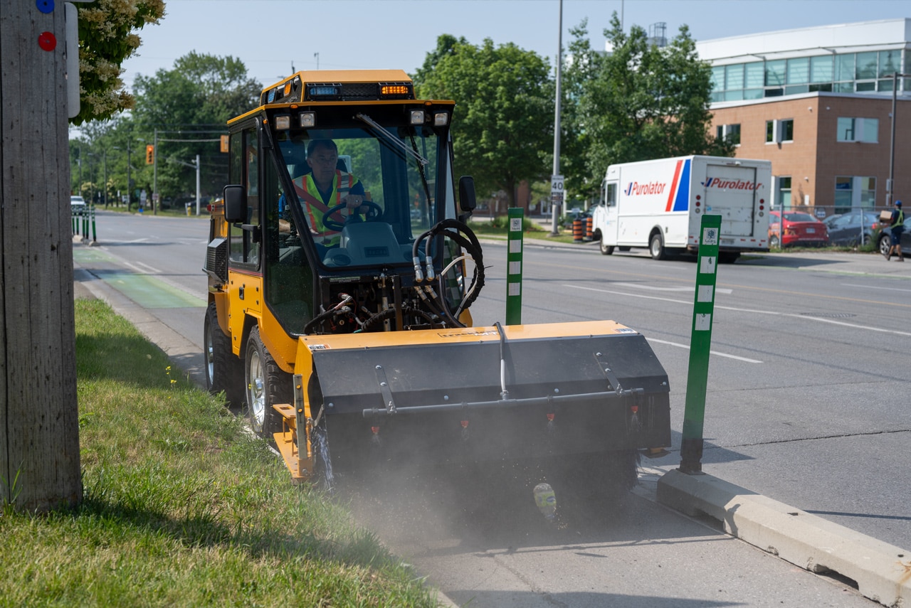 trackless vehicles mt7 machine and power angle sweeper attachment on sidewalk bike lane