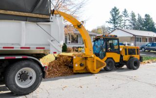 Trackless Vehicles MT7 tractor equipped with a Leaf Loader attachment loading leaves into a truck