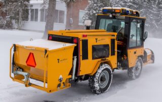 trackless vehicles rear-mount sidewalk spreader attachment on sidewalk municipal tractor