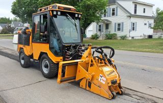 trackless vehicles cold planer attachment on sidewalk tractor working on sidewalk side view