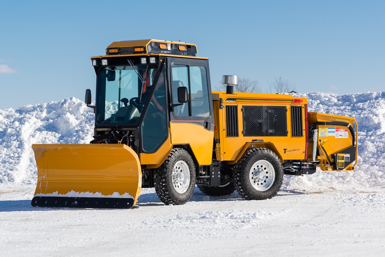 trackless vehicles double trip plow attachment on sidewalk tractor in snow side view