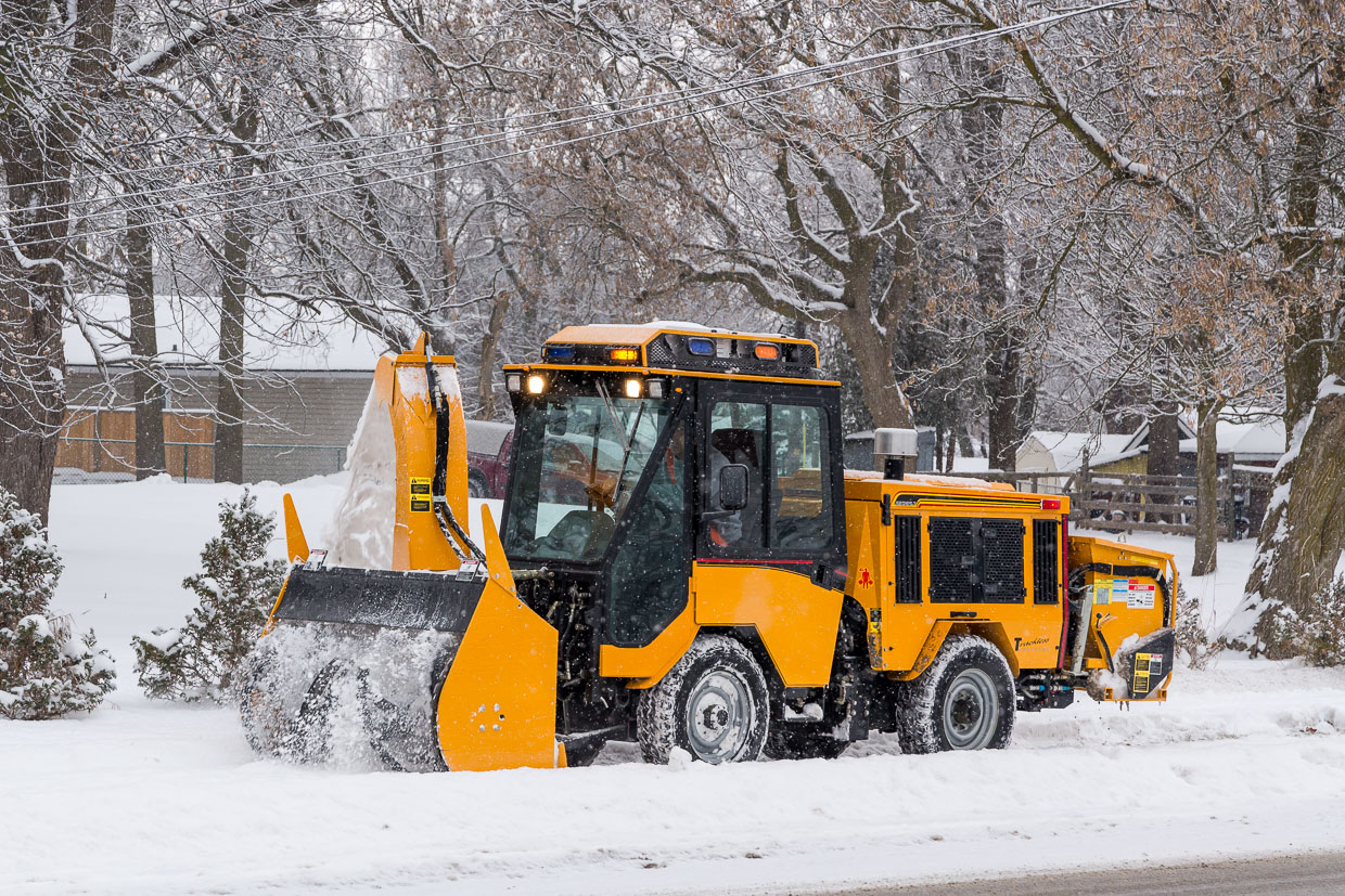 trackless vehicles ribbon snowblower in snow on sidewalk