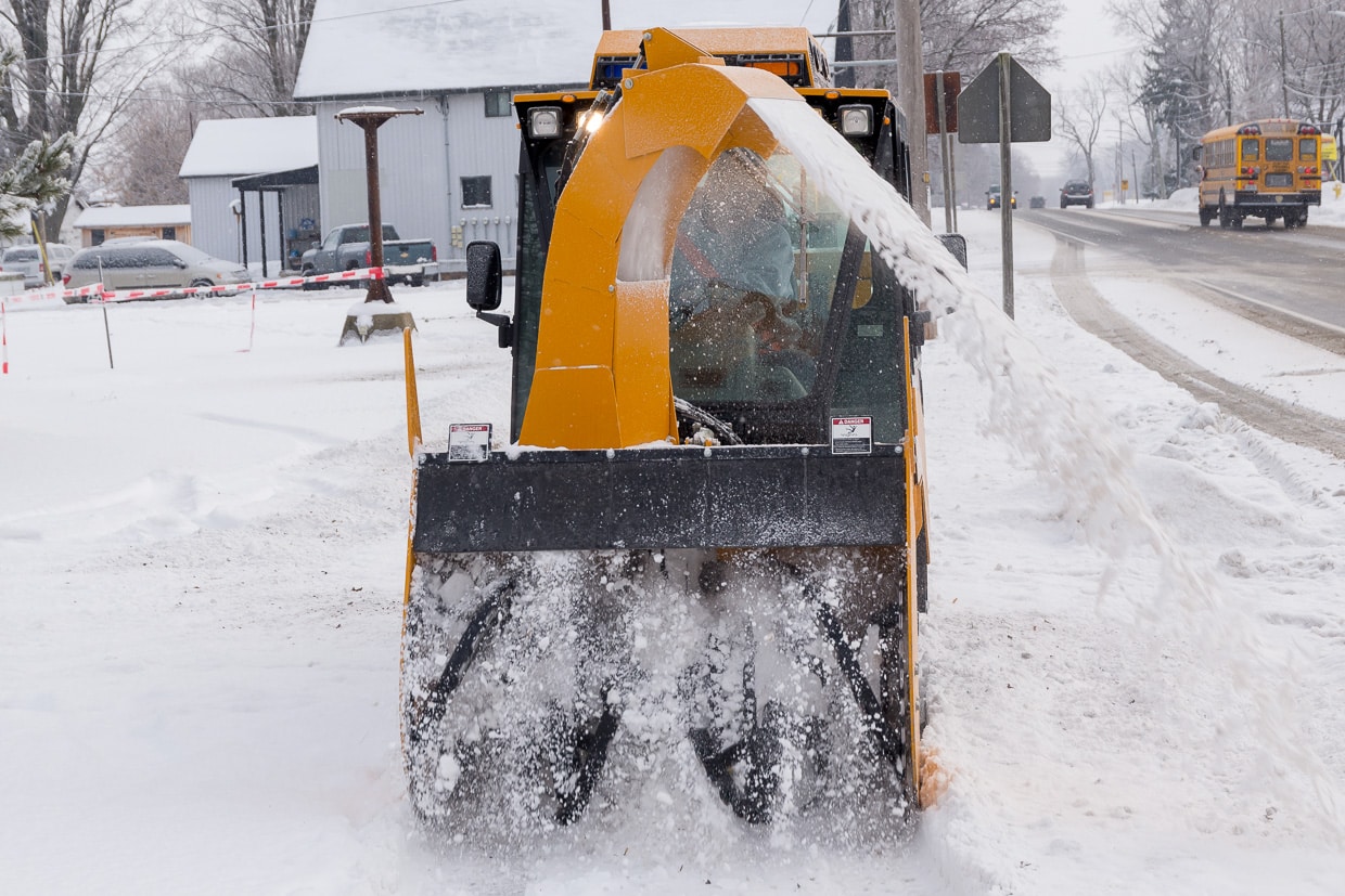 trackless vehicles ribbon snowblower in snow on sidewalk