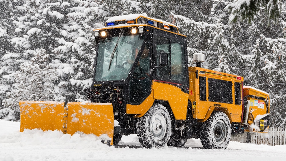 trackless vehicles 5-position folding v-plow attachment on sidewalk tractor in snow side front view