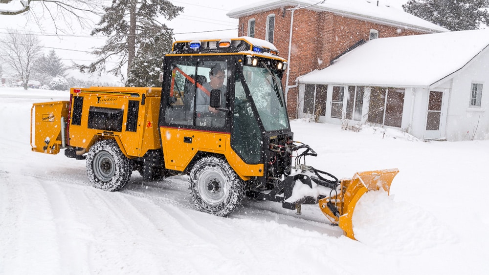 trackless vehicles 5-position folding v-plow attachment on sidewalk tractor in snow side view