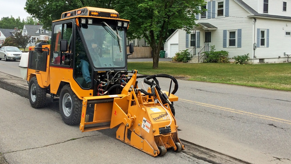 trackless vehicles cold planer attachment on sidewalk tractor working on sidewalk side view