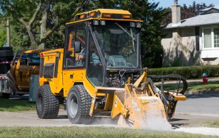 trackless vehicles cold planer attachment on sidewalk tractor working on sidewalk side view